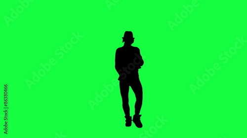 Silhouette of a girl in the hat dancing like the king of pop. Chroma key background. Silhouette of a woman dancing against a green background
