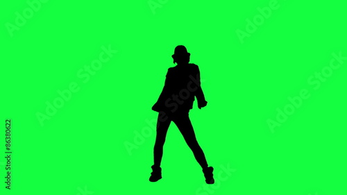 Silhouette of a girl in the hat dancing like the king of pop. Chroma key background. Silhouette of a woman dancing against a green background

