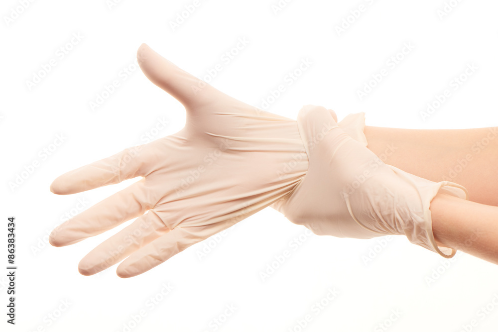 Female doctor's hands putting on white sterilized surgical gloves