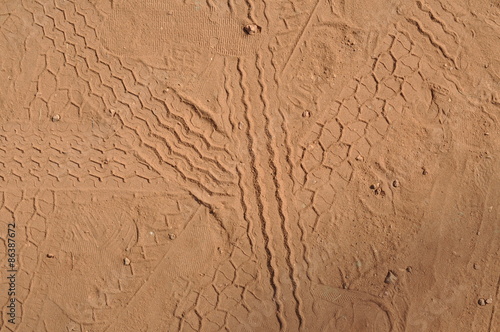 Fototapeta Naklejka Na Ścianę i Meble -  Tread marks on the ground. Red Earth background