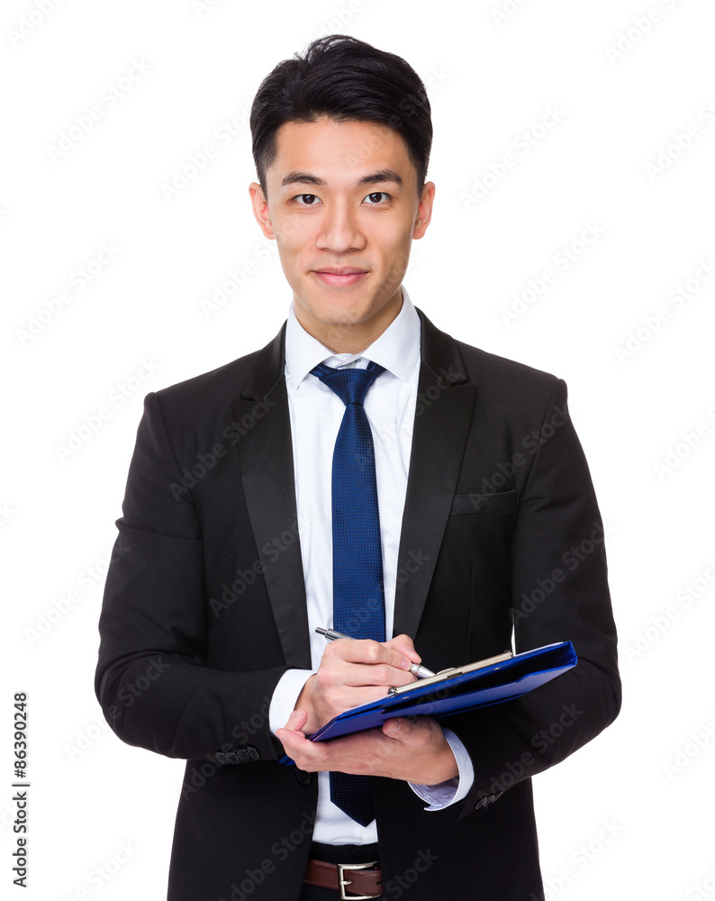 Young businessman take note on clipboard