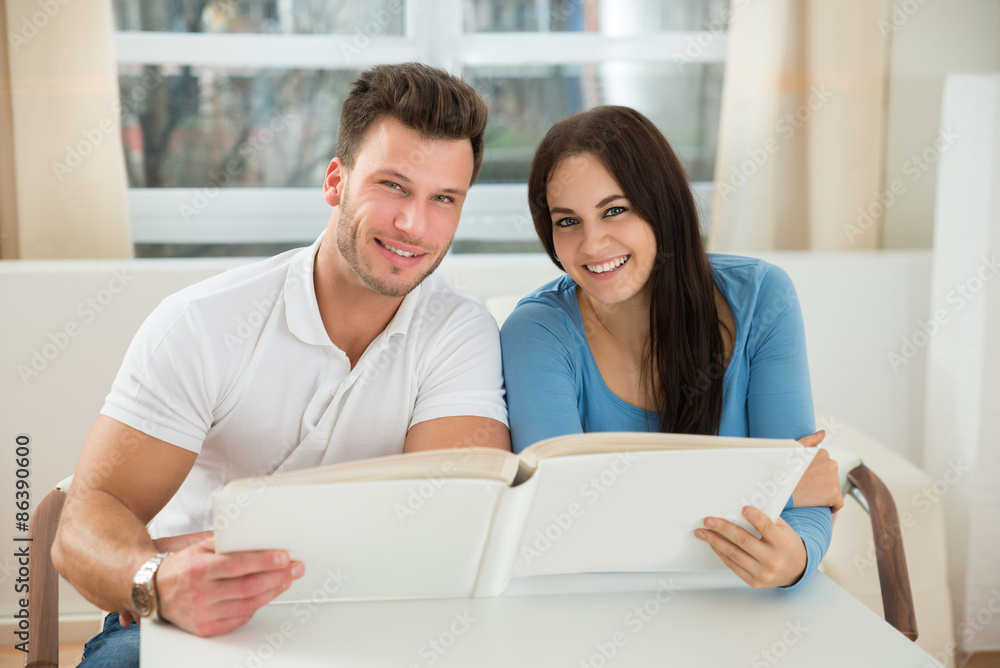 Happy Couple Holding Photo Album Happy Couple Holding Photo Album