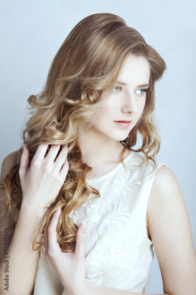Tender young woman with long curtly blond hair