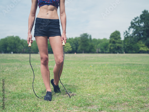 Fit woman in park with jump rope