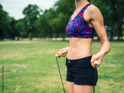 Fit woman in park with jump rope