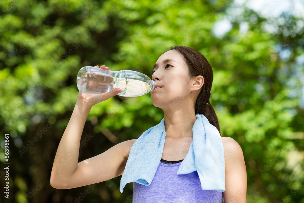 Young woman having rest after sport exercises holding bottle of Young woman having rest after sport exercises holding bottle of