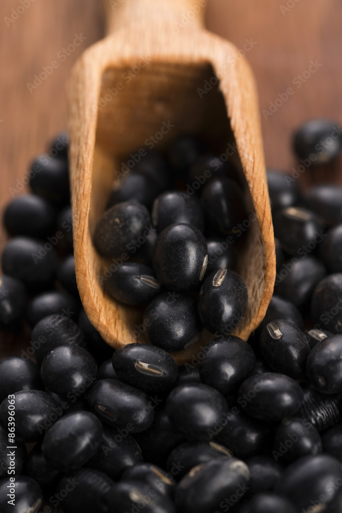 A lot of black soybeans on wooden background A lot of black soybeans on wooden background