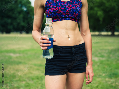 Fit woman with water bottle in park