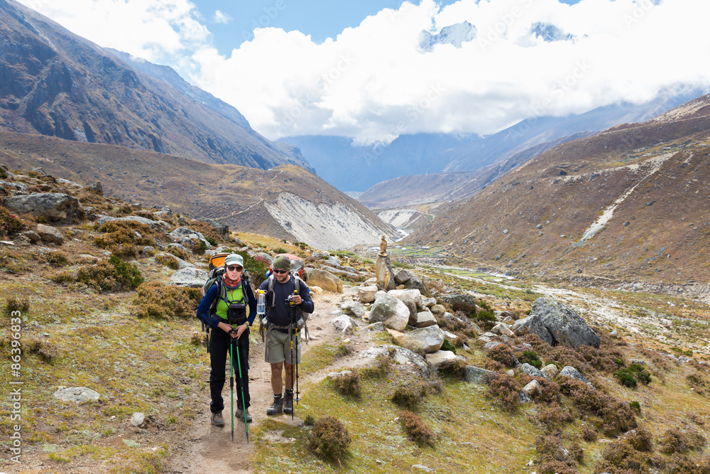 Couple backpackers hiking mountain trail in Nepal.