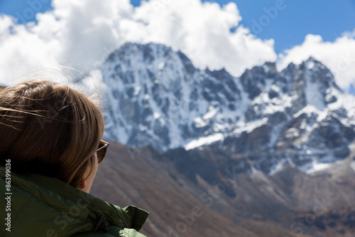 Young woman tourist looking at mountains ridge view.