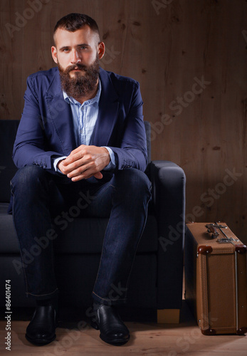 Businessman sitting the sofa in office lobby, isolated on dark