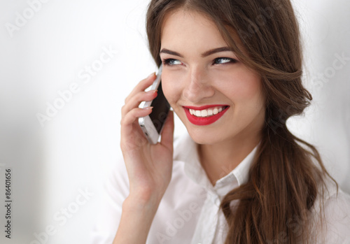 Smiling businesswoman talking on the phone at the office