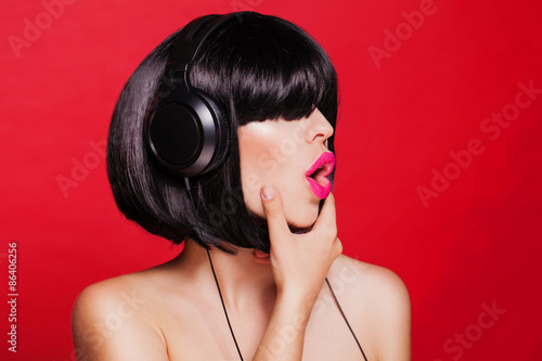 Woman listening to music on headphones enjoying a singing