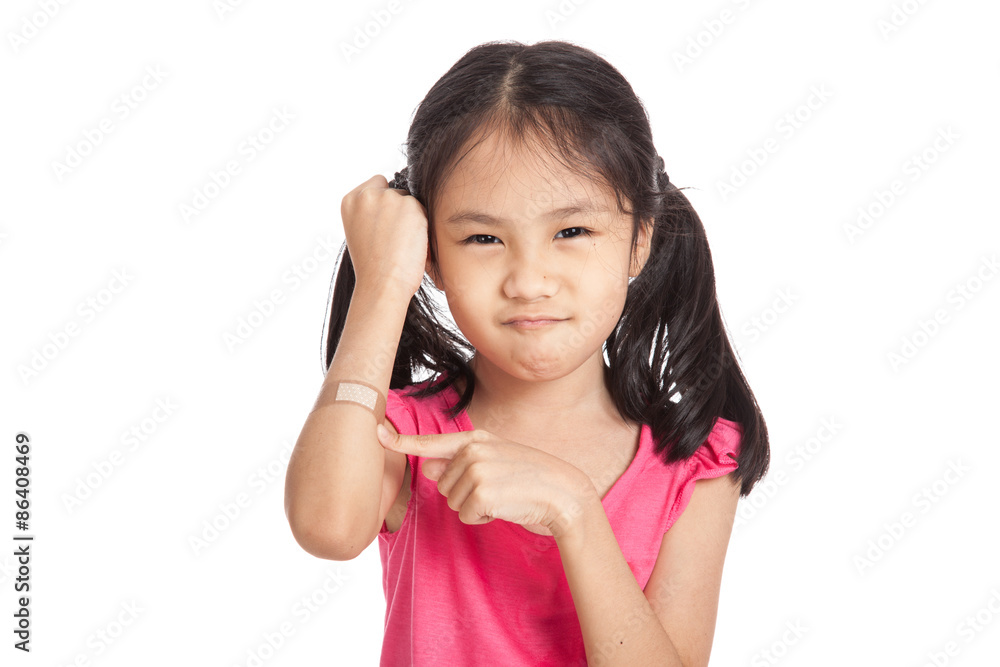 Little asian girl point to bandage on her arm Little asian girl point to bandage on her arm