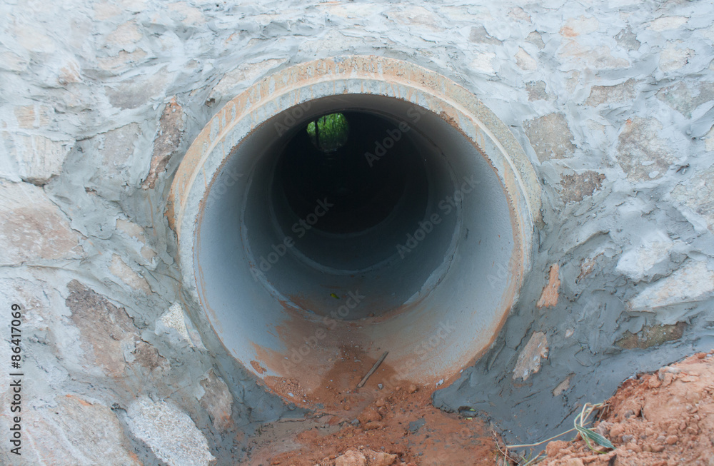 Large cement drainage pipe buried underground. Large cement drainage pipe buried underground.