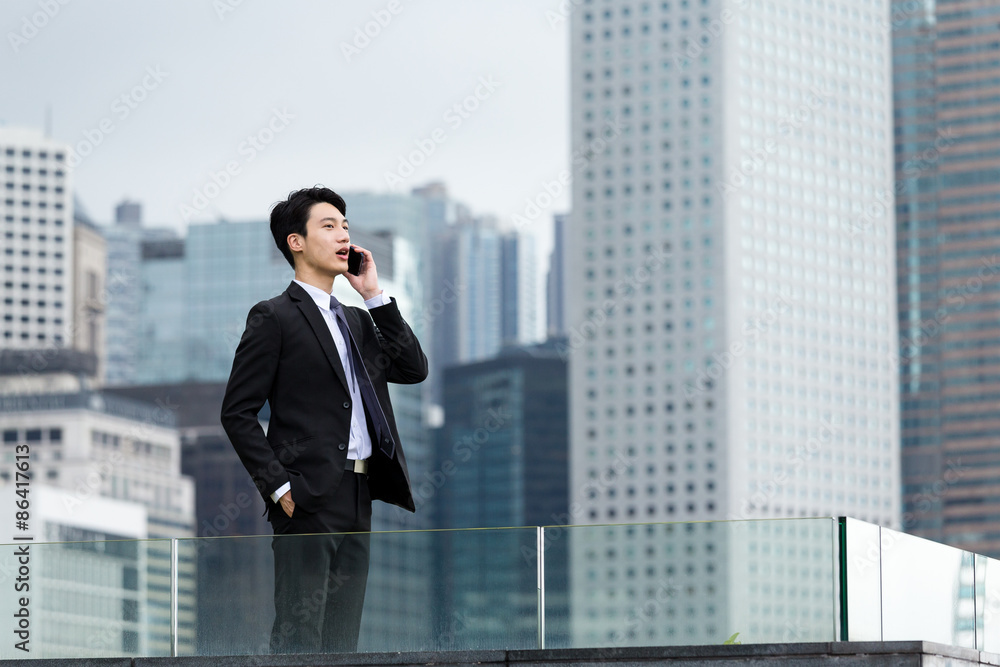 Asian businessman talk to cellphone at Hong Kong Asian businessman talk to cellphone at Hong Kong