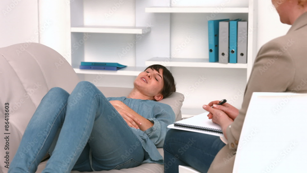 Woman lying on sofa and speaking with psychologist Woman lying on sofa and speaking with psychologist