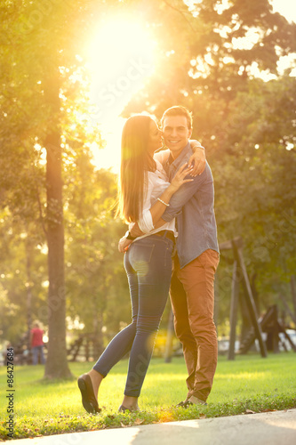 Romantic couple hugging in sunny park