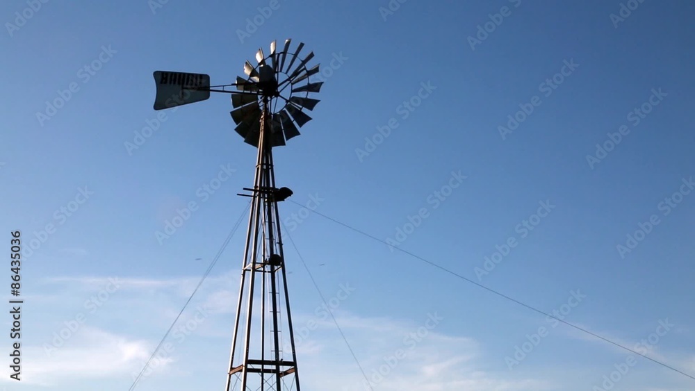 Windmill with blue sky and clouds, top of a windmill moving because of the wind, clouds and blue sky on the background and bird appears flying on the sky.
Windmill with blue sky and clouds, top of a windmill moving because of the wind, clouds and blue sky on the background and bird appears flying on the sky.