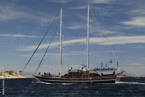 sailing ship with people on the red sea