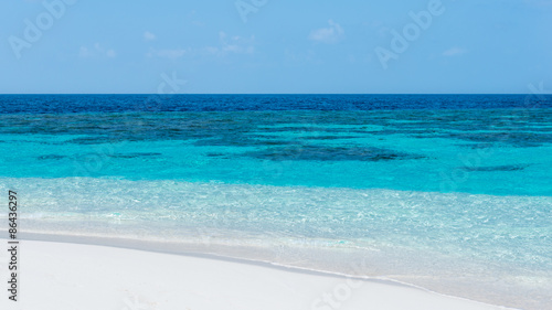 Panorama of  tropical island with turquoise lagoon. Bright blue sky with clouds low over the ocean. Summer joyful day