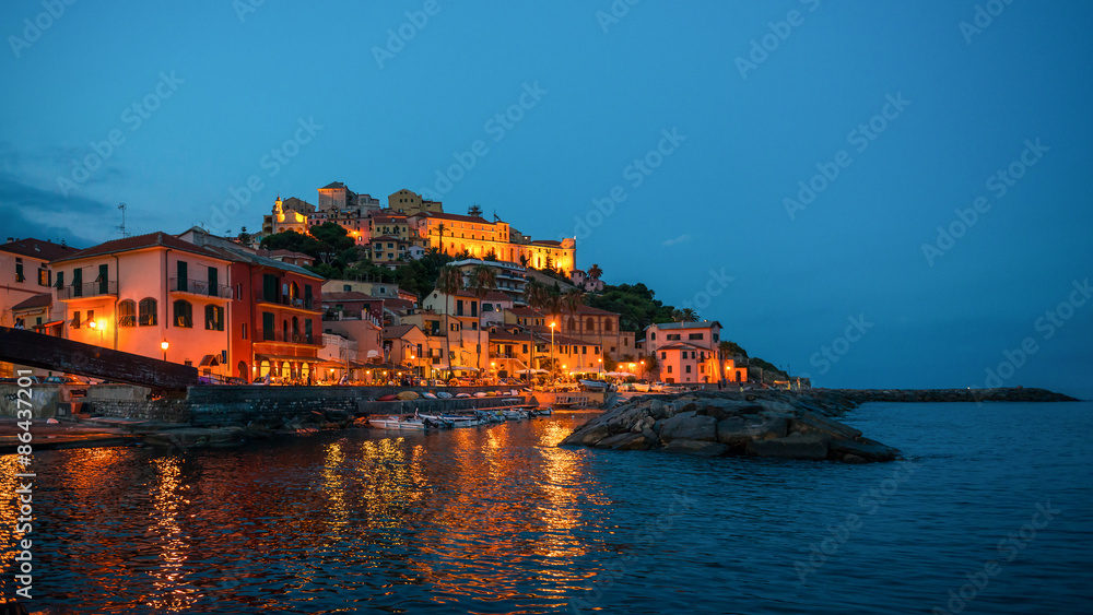 Town Imperia on the shore of  Mediterranean Sea, Italy.  Night lights reflected in the water.
