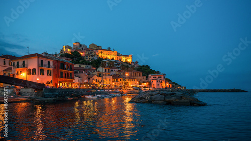 Town Imperia on the shore of Mediterranean Sea, Italy. Night lights reflected in the water.