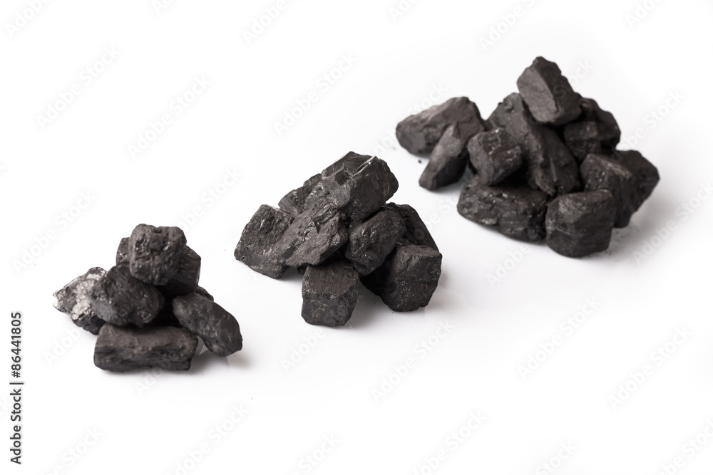 Three small piles of black coal on a white glossy background Three small piles of black coal on a white glossy background