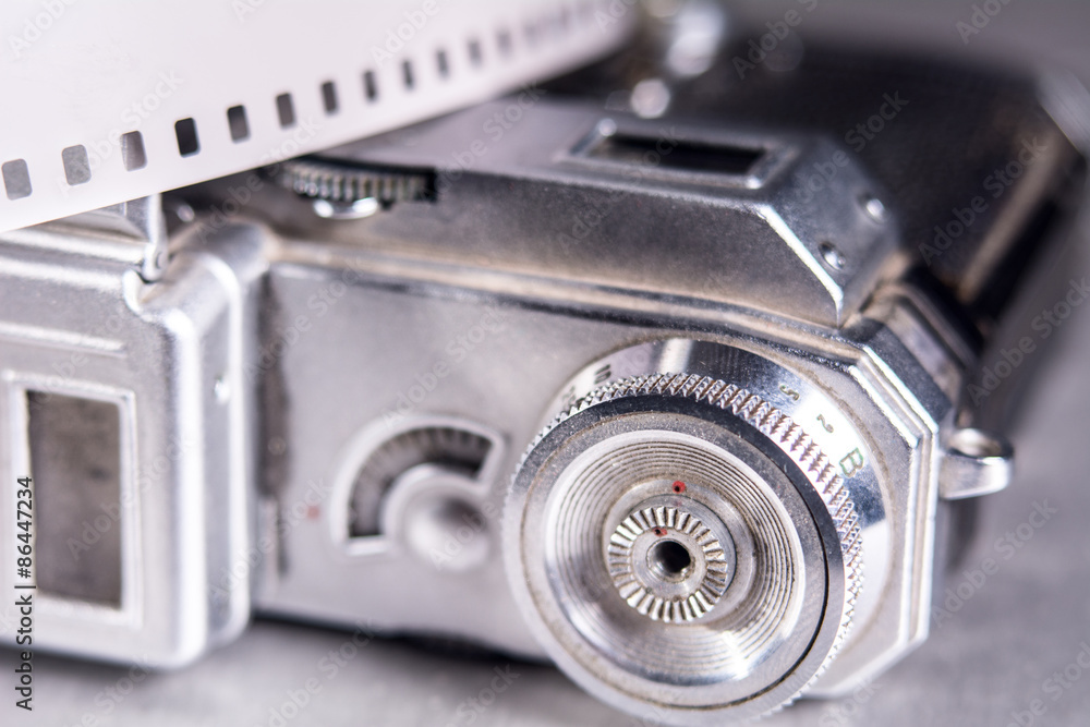Close-up of old photo camera and photo film 35 mm on the backgro Close-up of old photo camera and photo film 35 mm on the backgro