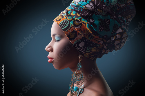 young beautiful fashion model with traditional african style with scarf, earrings and makeup on dark blue background.  
Developed from RAW, edited with special care and attention. 
 photo