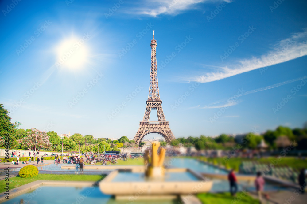 summer day the sun shines over the Eiffel Tower symbol of Paris.
