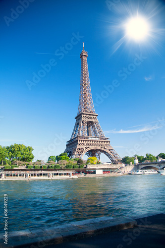 letni dzień słońce świeci nad symbolem paryskiej wieży Eiffla.