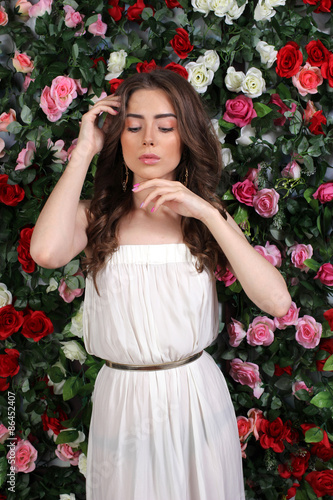 Girl in white dress posing on floral background