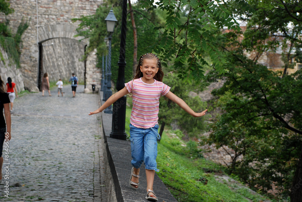 Little girl running and smiling in a park in Budapest, Hungary Little girl running and smiling in a park in Budapest, Hungary