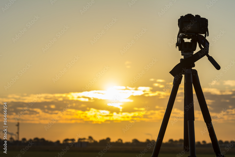 Silhouette from a recording camera on a tripod during sunrise Silhouette from a recording camera on a tripod during sunrise