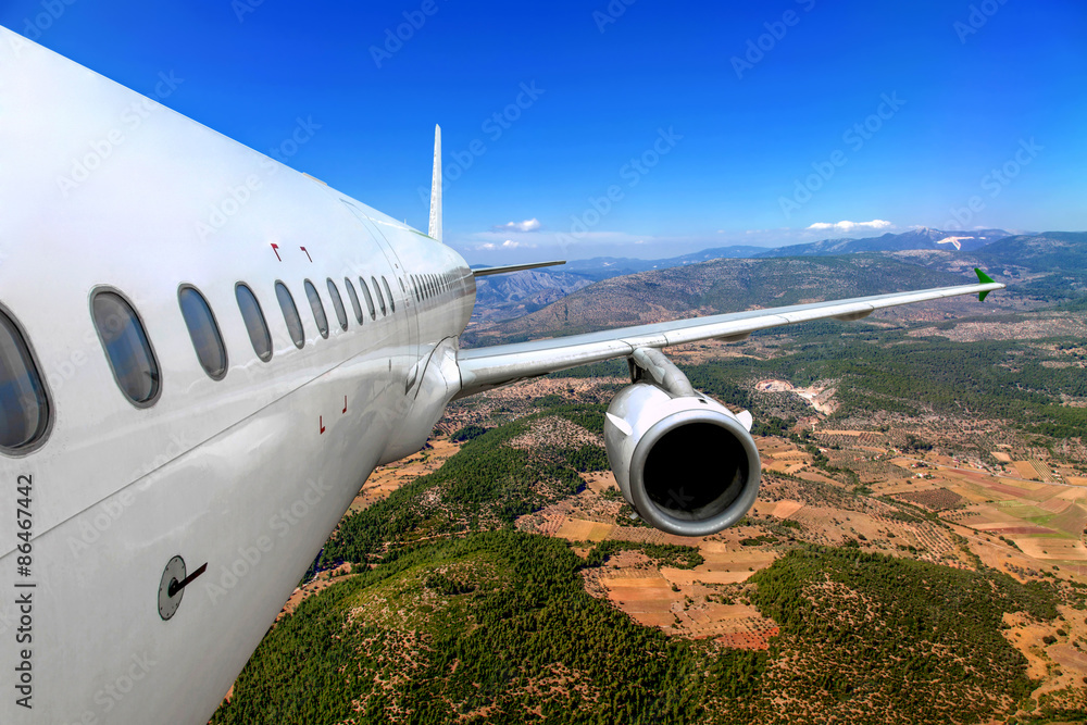 Fototapeta premium Passenger airplane flying over the ground