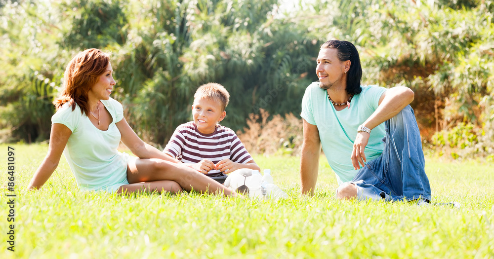 Fototapeta premium family of three resting at park