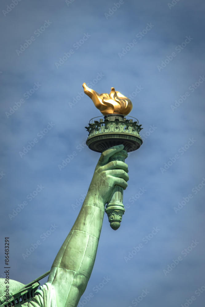 Closeup of the torch of Lady Liberty on a cloudy day