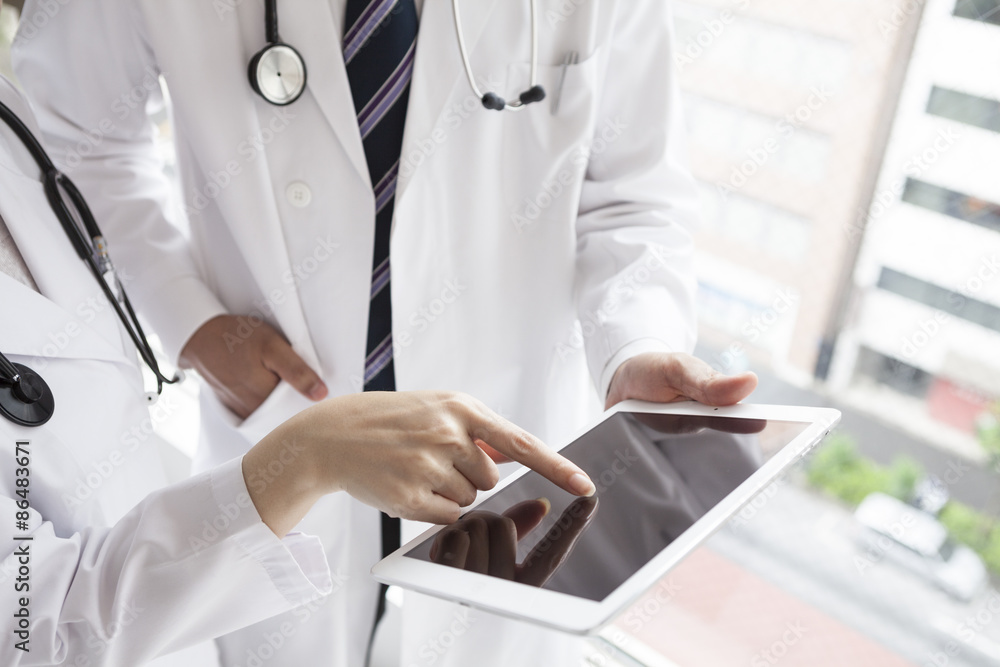 Doctors are looking at electronic medical records at the window Doctors are looking at electronic medical records at the window