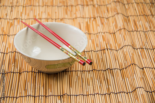 Canvas Print bowl and chopsticks on bamboo mat.