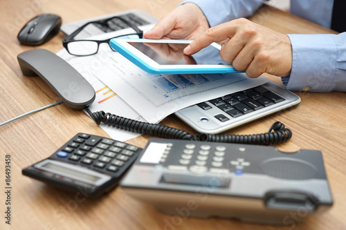 busy businessman in office with full of accessories on desk wit