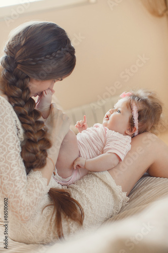 Happy mother playing with child at home