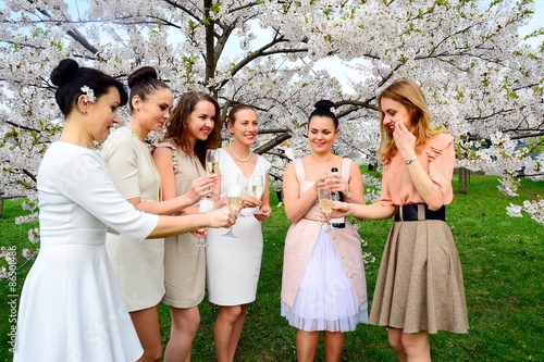 Girls with champagne celebrating in sakura's garden. © bokstaz