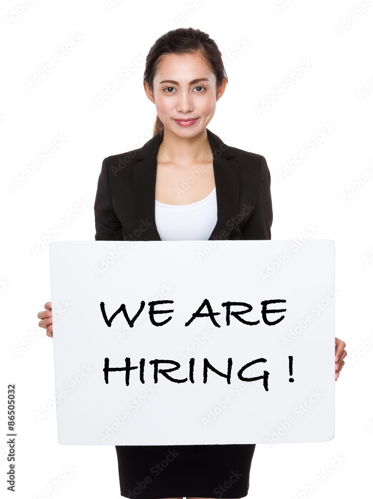 Asian businesswoman showing a board showing with we are hiring p Asian businesswoman showing a board showing with we are hiring p
