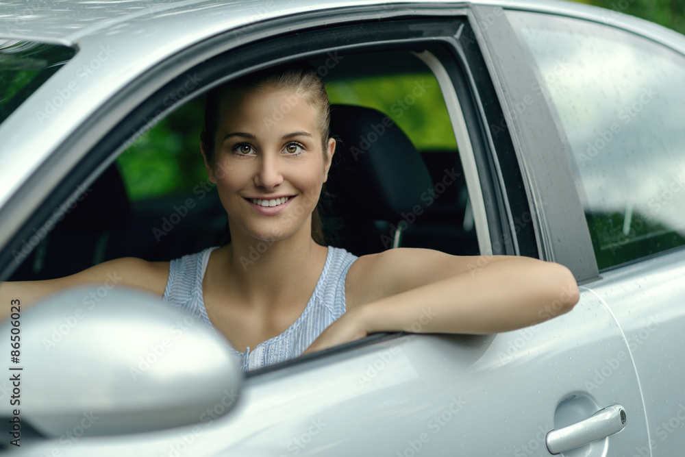 Smiling attractive woman driving a car