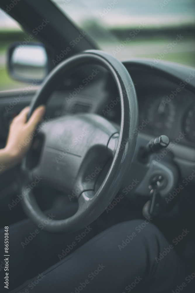 Woman's hand driving a car. Unrecognizable person.