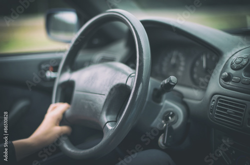Woman's hand driving a car. Unrecognizable person. © M-Production