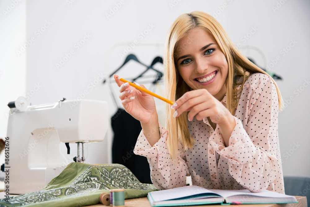 Female designer sitting at her workplace in workshop a Female designer sitting at her workplace in workshop a