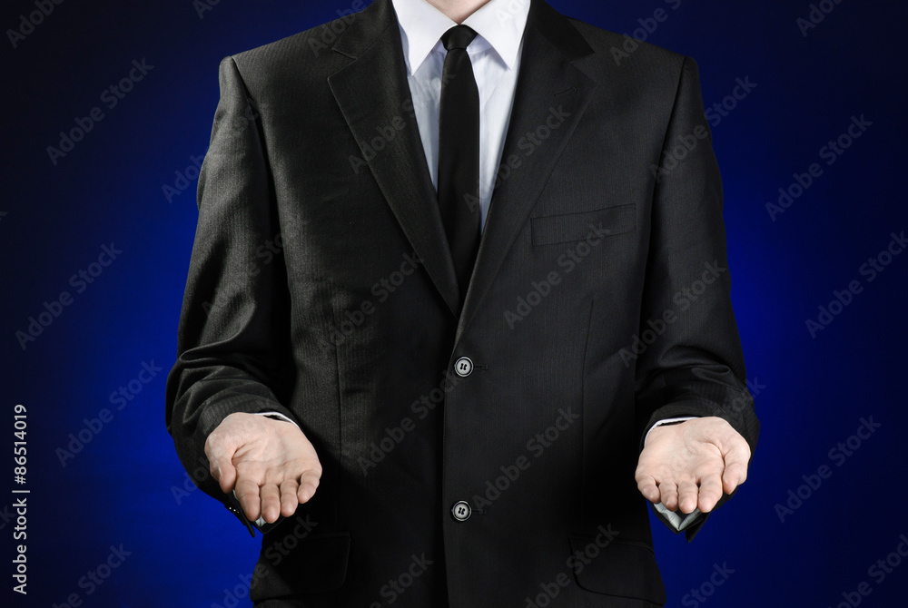 Businessman and gesture topic: a man in a black suit and white shirt showing gestures with hands on a dark blue background in studio isolated