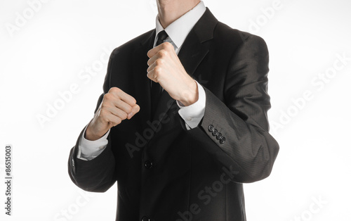 Businessman and gesture topic: a man in a black suit holding his fists in front of him, business struggle